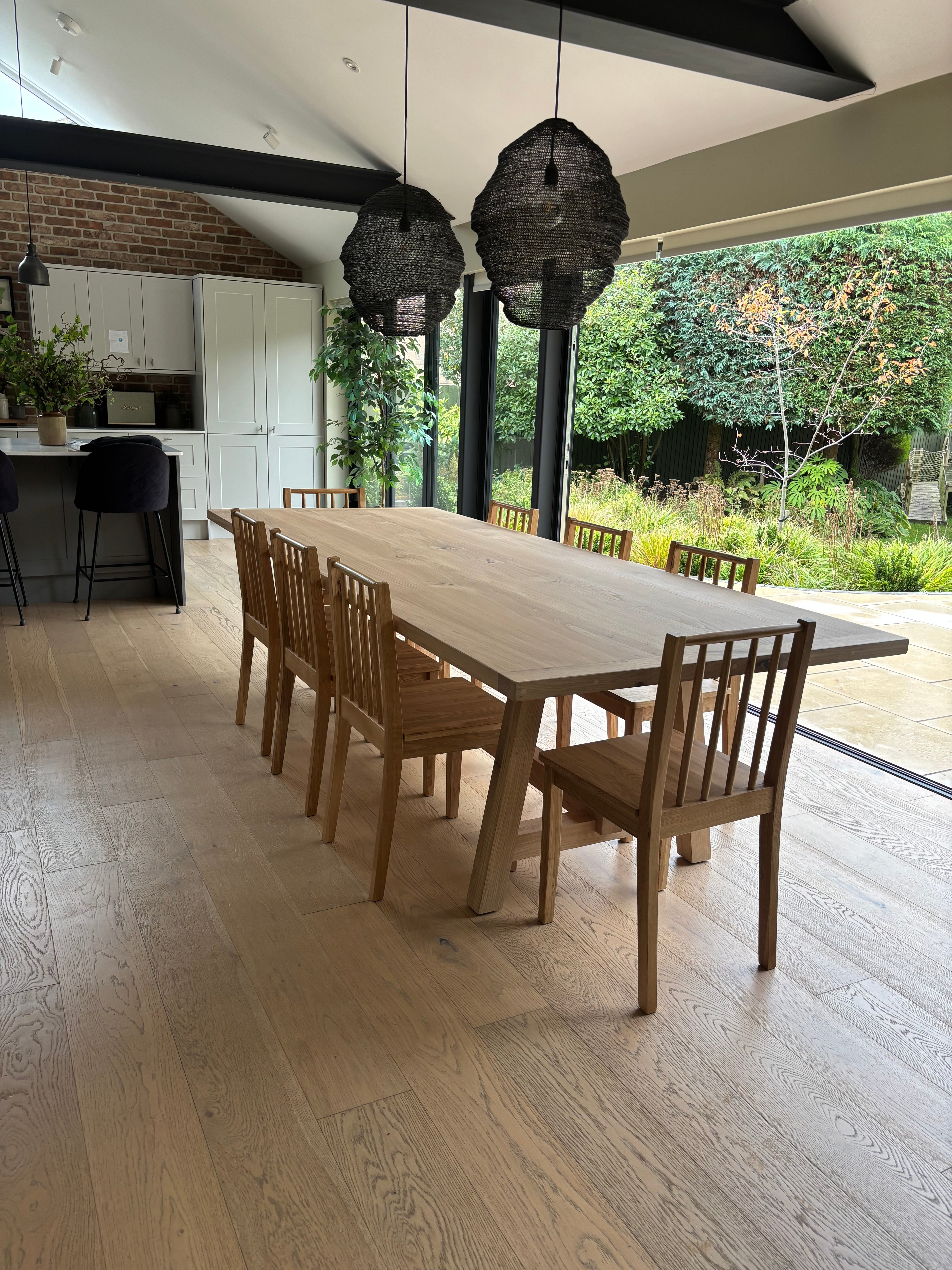 Wooden handmade furniture set on a patio with a garden view