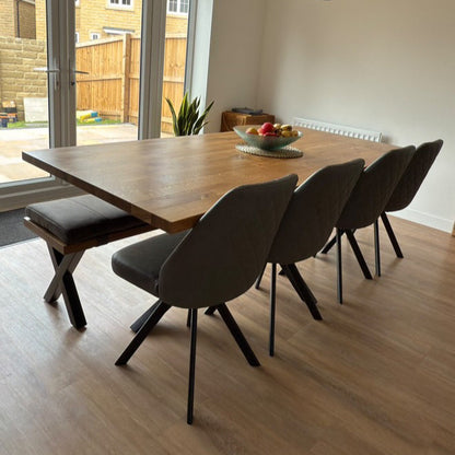 Dining room with wooden table and chairs near a sliding glass door.