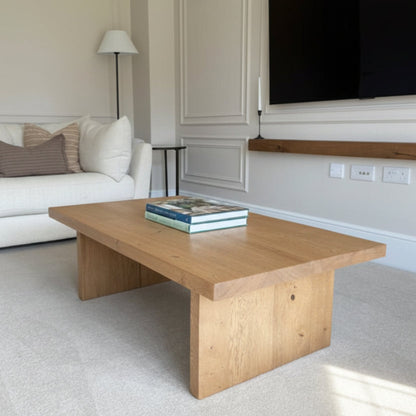 Living room with a wooden coffee table, white sofa, and TV.