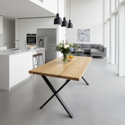 Modern kitchen and living room with a wooden dining table, gray sofa, and kitchen appliances.