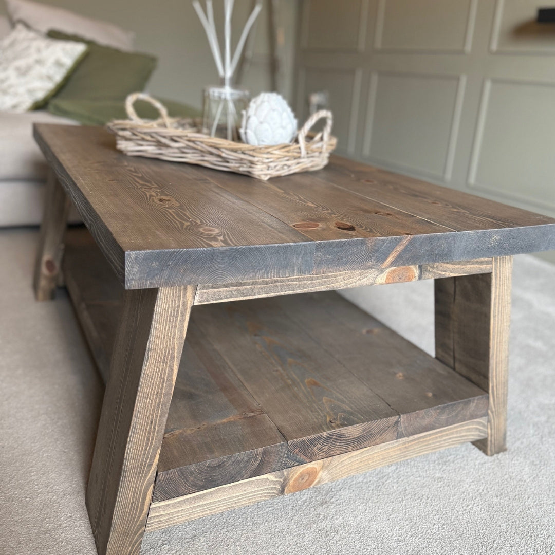 Wooden coffee table with a wicker basket and decorative items in a living room setting.