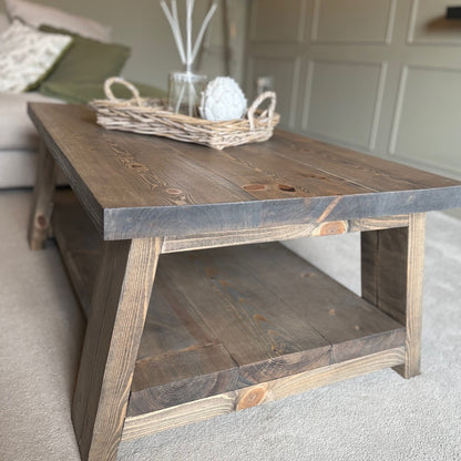 Wooden coffee table with a wicker basket and decorative items in a living room setting.