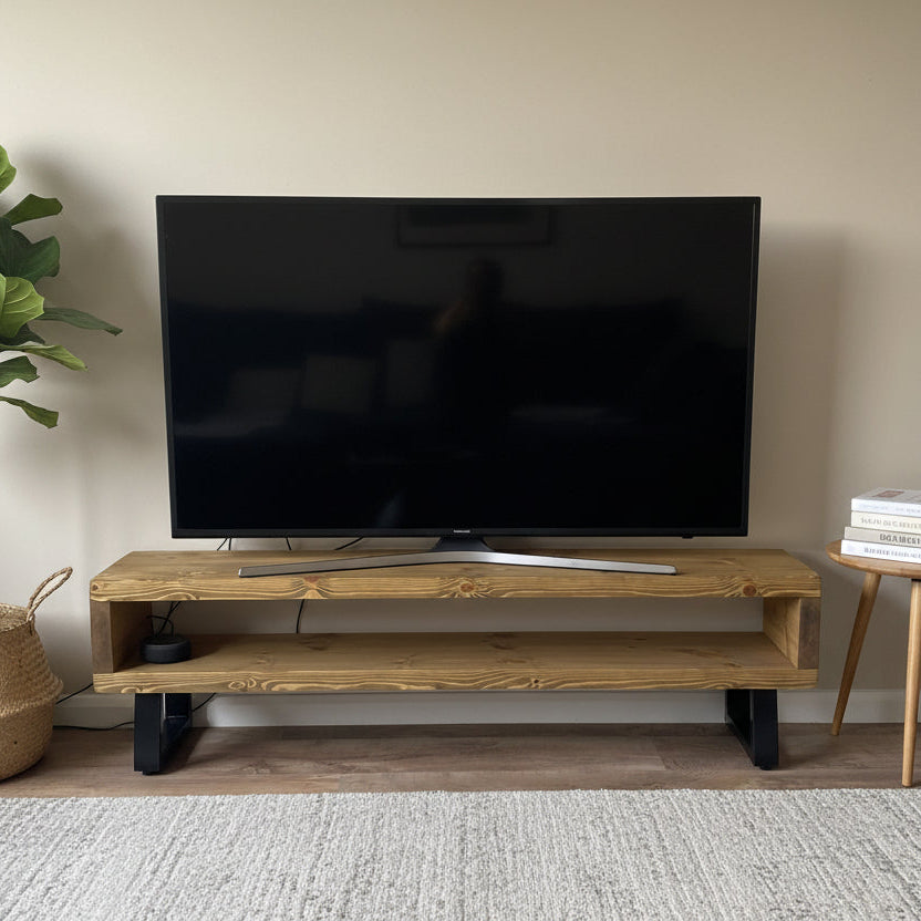 Large flat-screen TV on a wooden stand against a white wall.